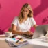Junge Frau beim Bestellen in Online Druckerei am Laptop